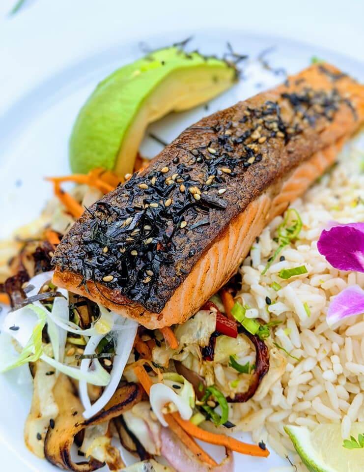 A plate with salmon, rice and avocado.