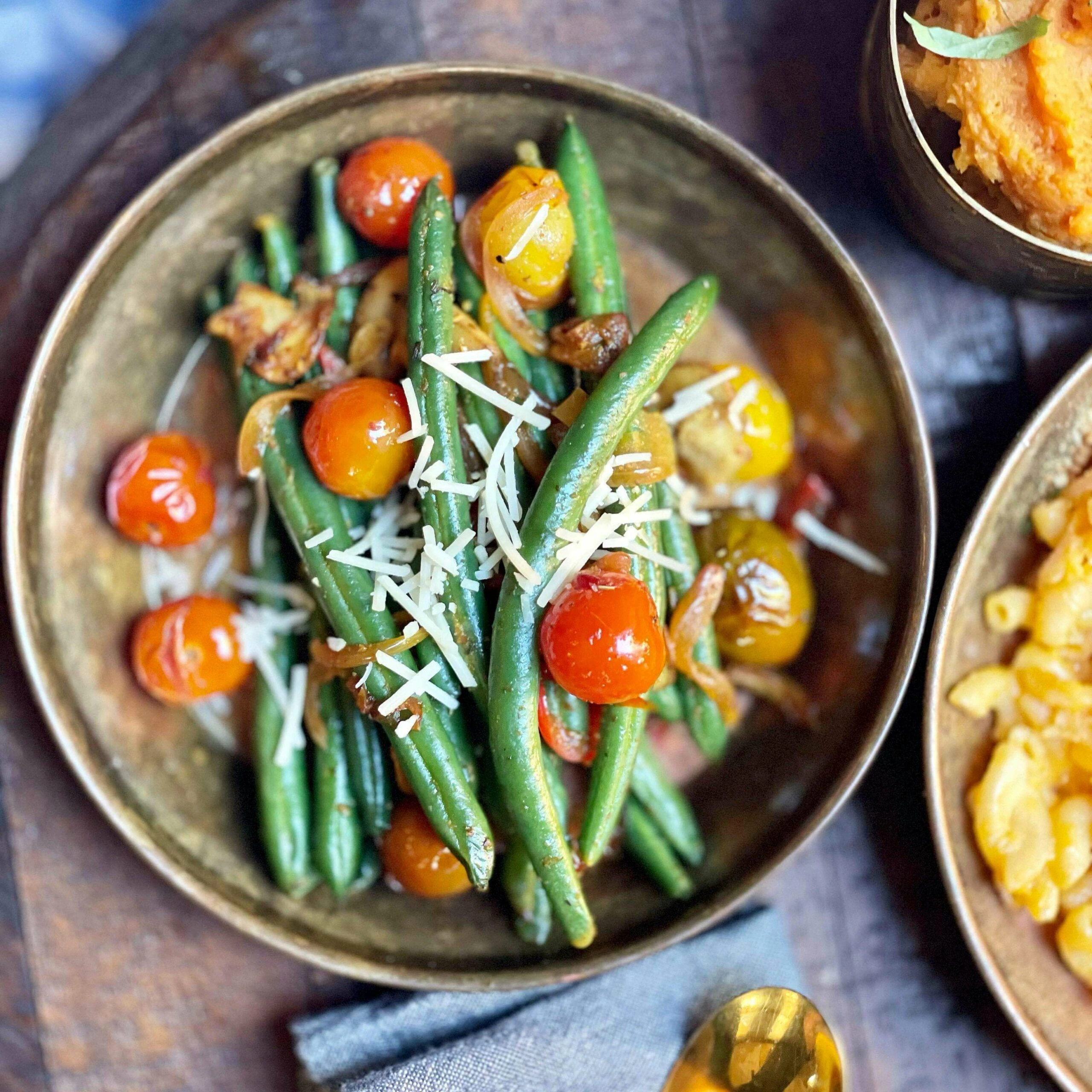 Green beans and tomatoes in a bowl on a wooden table.